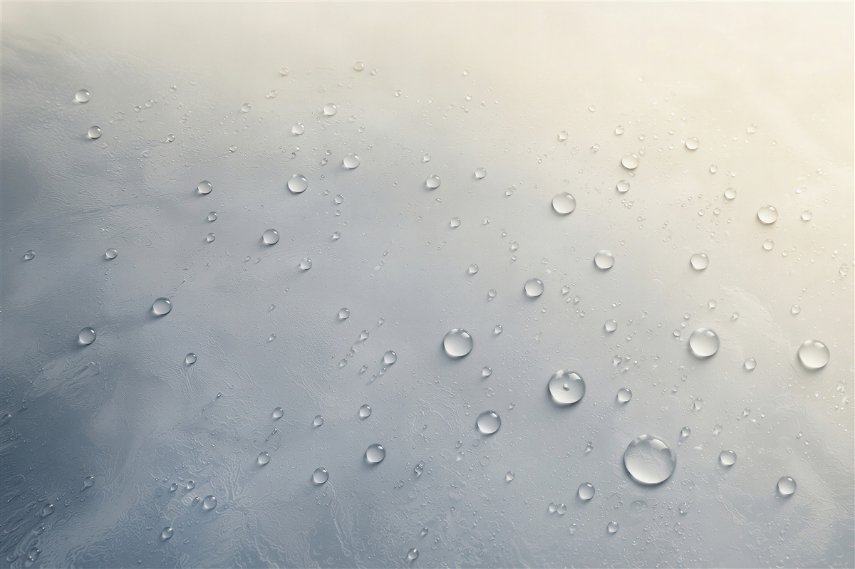 Fotobehang waterdruppels op glazen oppervlak in blauw-beige tinten