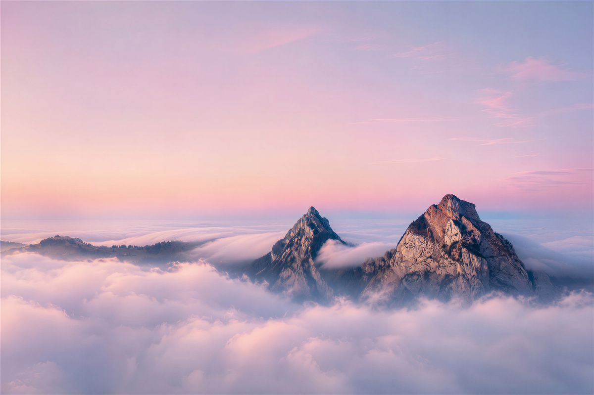 Fotobehang roze lucht boven bewolkte bergen